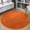 Jednofarebný okrúhly koberec oranžovej farby