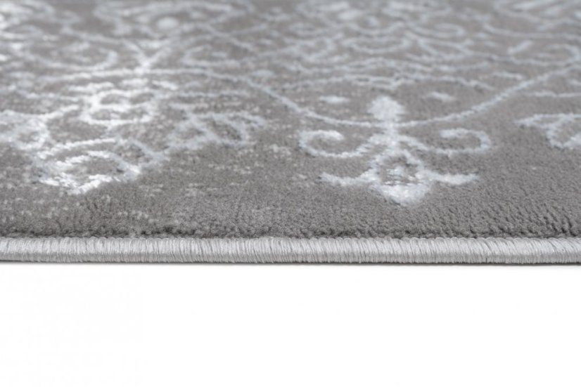 Moderný koberec sivej farby s orientálnym vzorom bielej farby