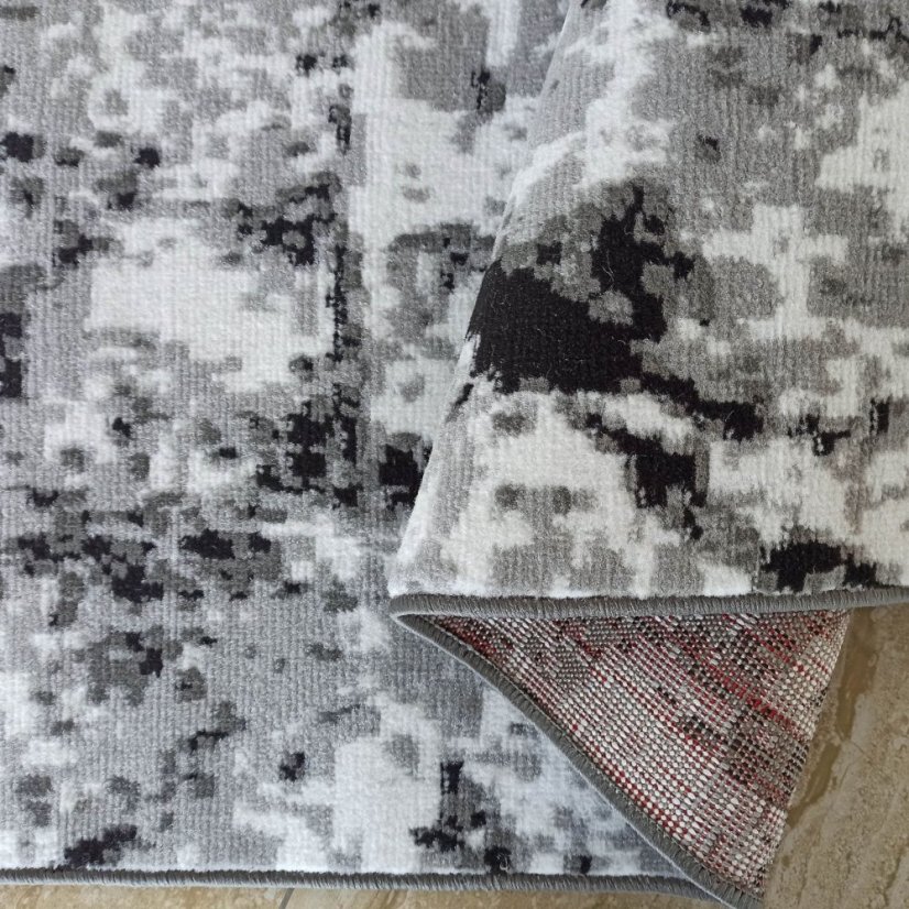 Moderný koberec s kamuflážnym vzorom v sivej farbe