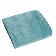 Cuvertură de pat din catifea matlasată pe un pat verde menta