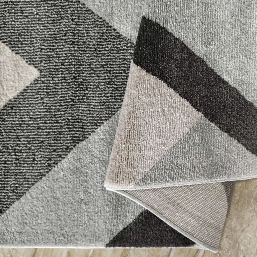 Moderný koberec s geometrickými vzormi v sivých farbách