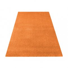Jednofarebný koberec oranžovej farby 