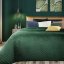 Cuvertură de pat elegantă pe un pat verde închis