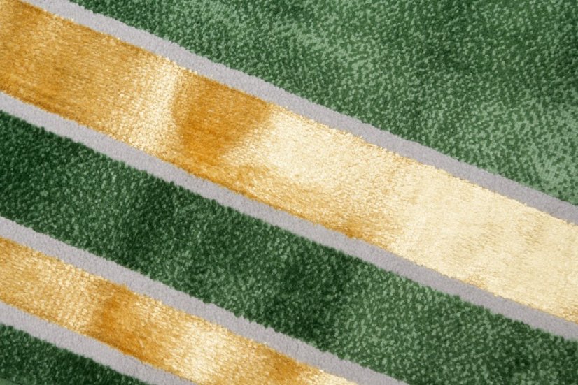 Trendy zelený koberec se zlatým vzorem po okrajích