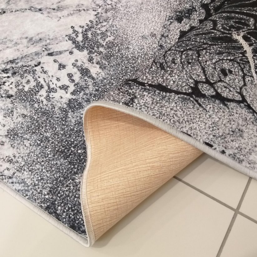 Čierno biely vzorovaný koberec s ozdobnými strapcami