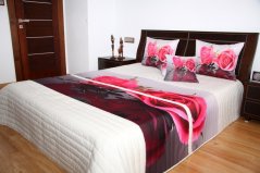 Cuvertură de pat albă cu un model de trandafir roz