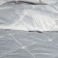 Cuvertură de pat matlasată într-o singură culoare pe un pat gri
