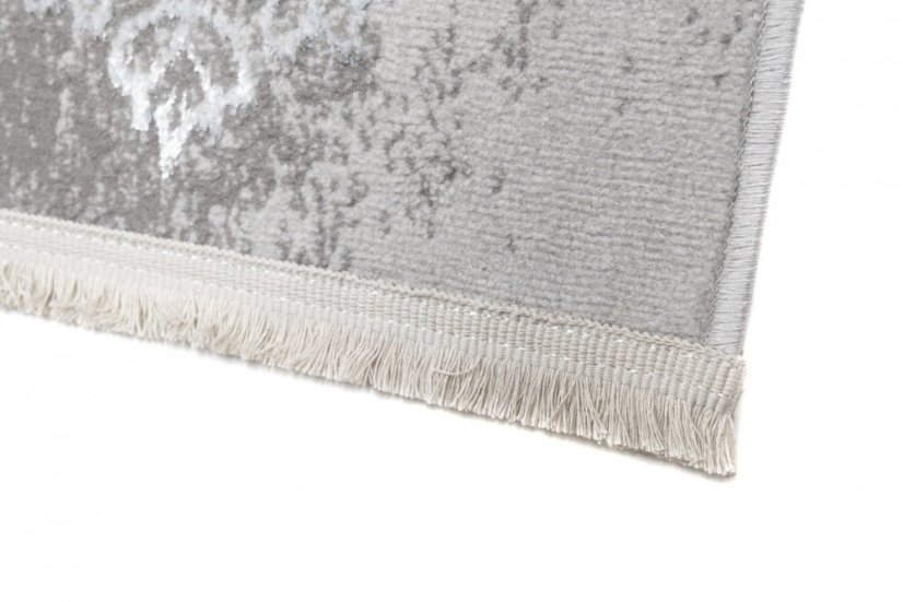 Moderný koberec sivej farby s orientálnym vzorom bielej farby