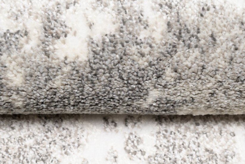 Dizajnový koberec s abstraktným vzorom v krémovej farbe