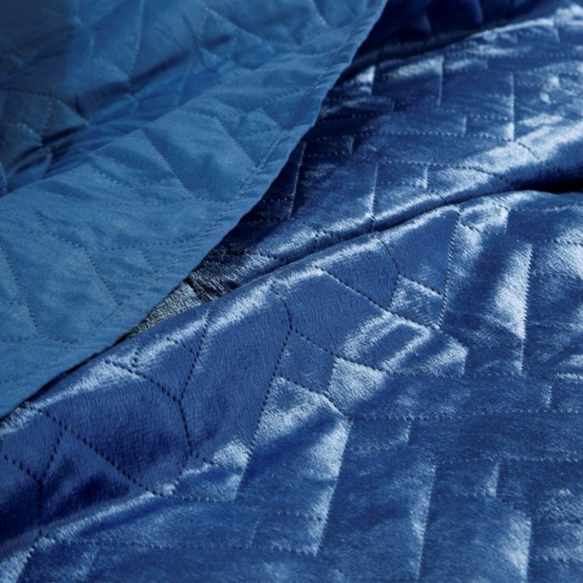 Jednobarevný přehoz na postel modré barvy s prošíváním