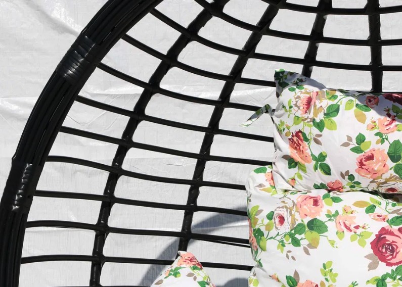 Štýlové závesné kreslo čiernej farby s rôznymi vankúšmi